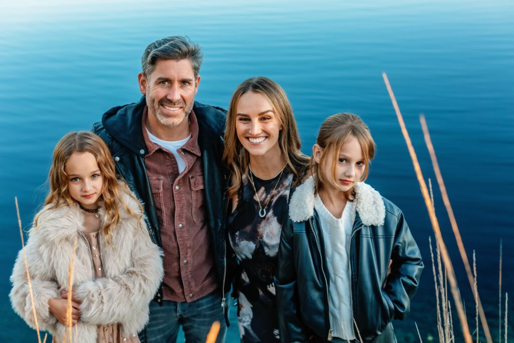 family with twin girls near a lake