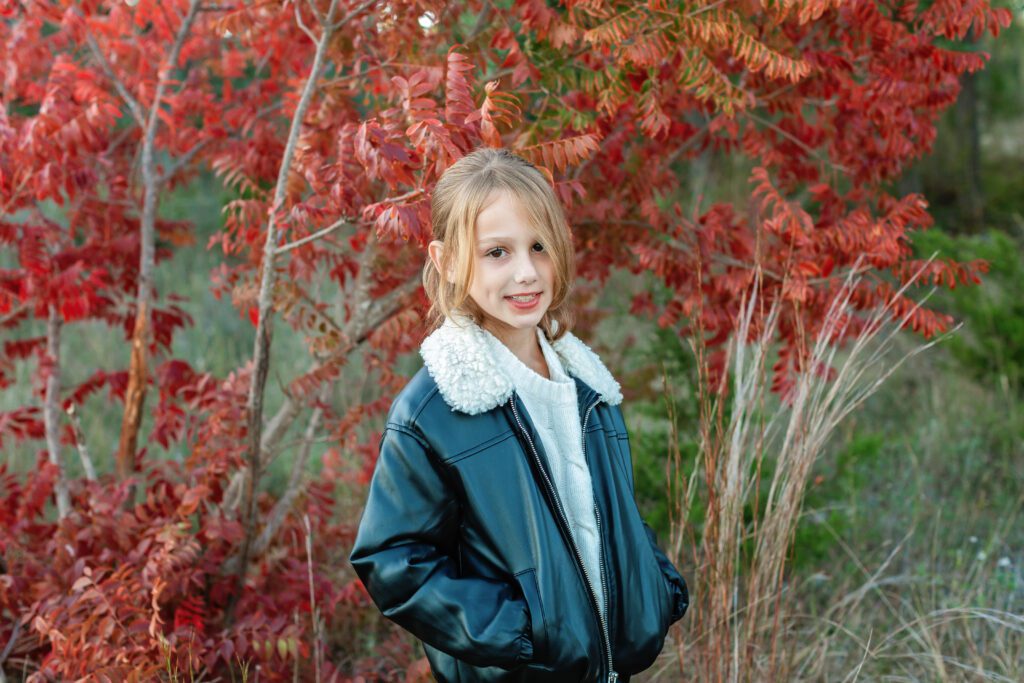 girl in leather jacket with fall leaves